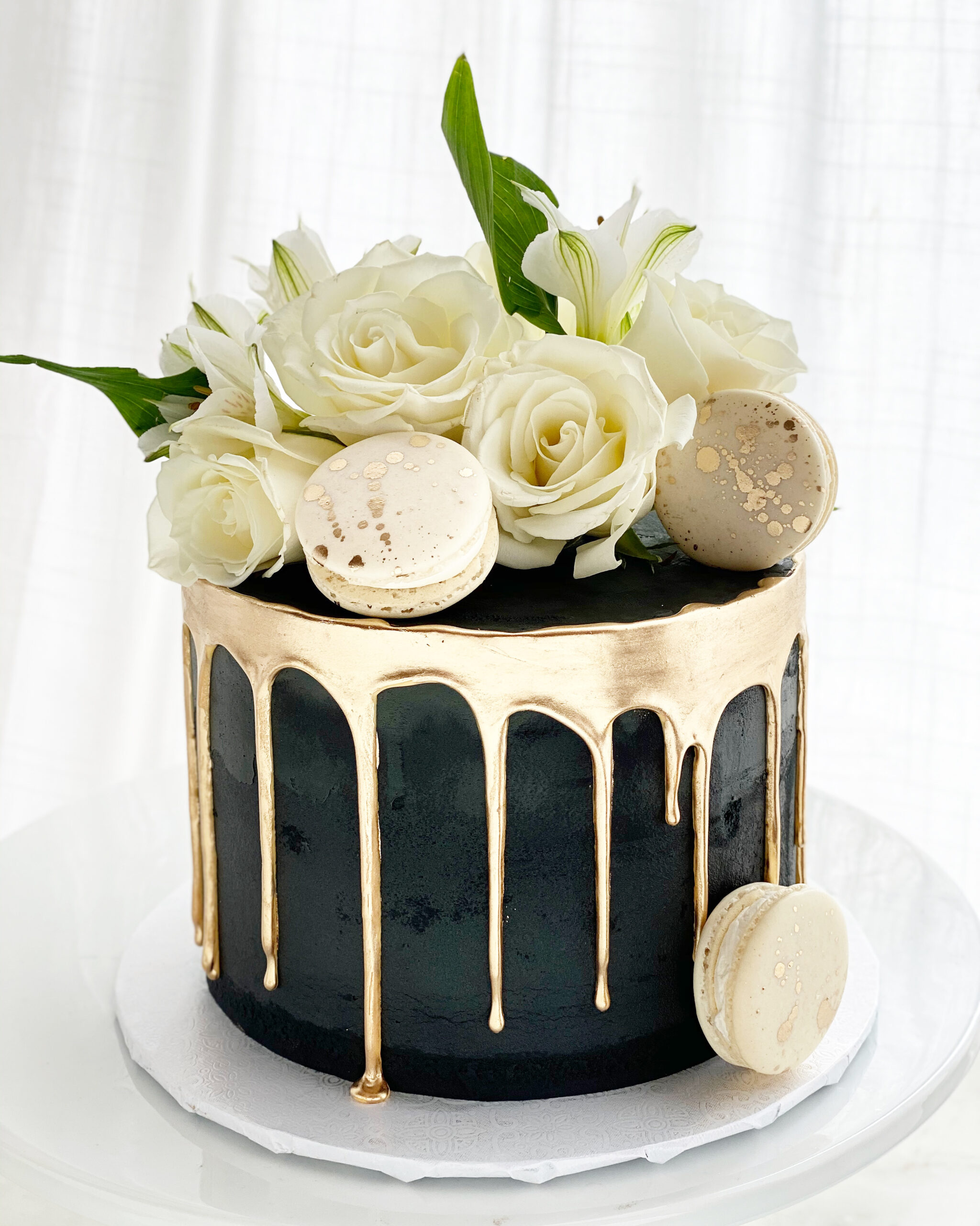 Mac And Flowers Black And Gold Drip Cake